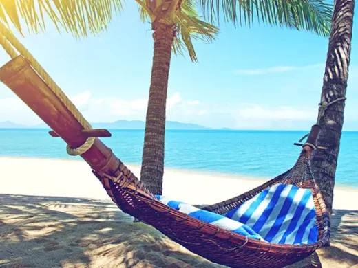 Empty-hammock-between-palms-trees-at-sandy-beach