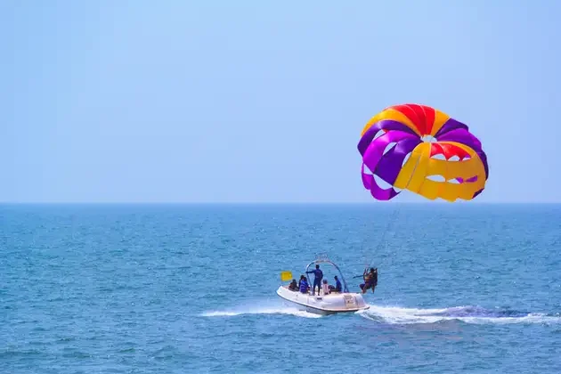 Tourists_parasailing_on_Candolim_Beach_in_Goa_India._687x478